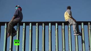Южноамериканская мечта: десятки мигрантов пытаются прорваться через стену на границе Мексики и США