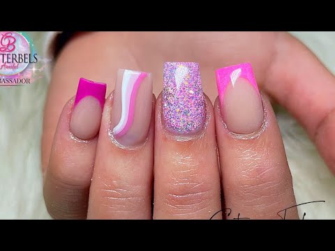 Pink French acrylic nails with glitter and swirly nail art