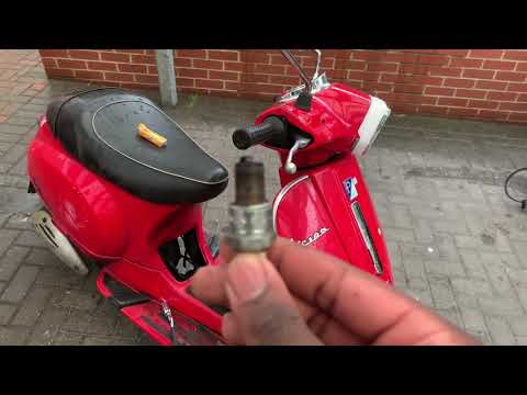 How do you replace the spark plug of the Piaggio Vespa 50 LX?