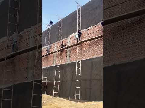 يستخدم عمال البناء بذكاء السلالم لتركيب سقالات لتجصيص الجدران.