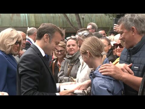 Emmanuel Macron greets residents after casting his vote | AFP