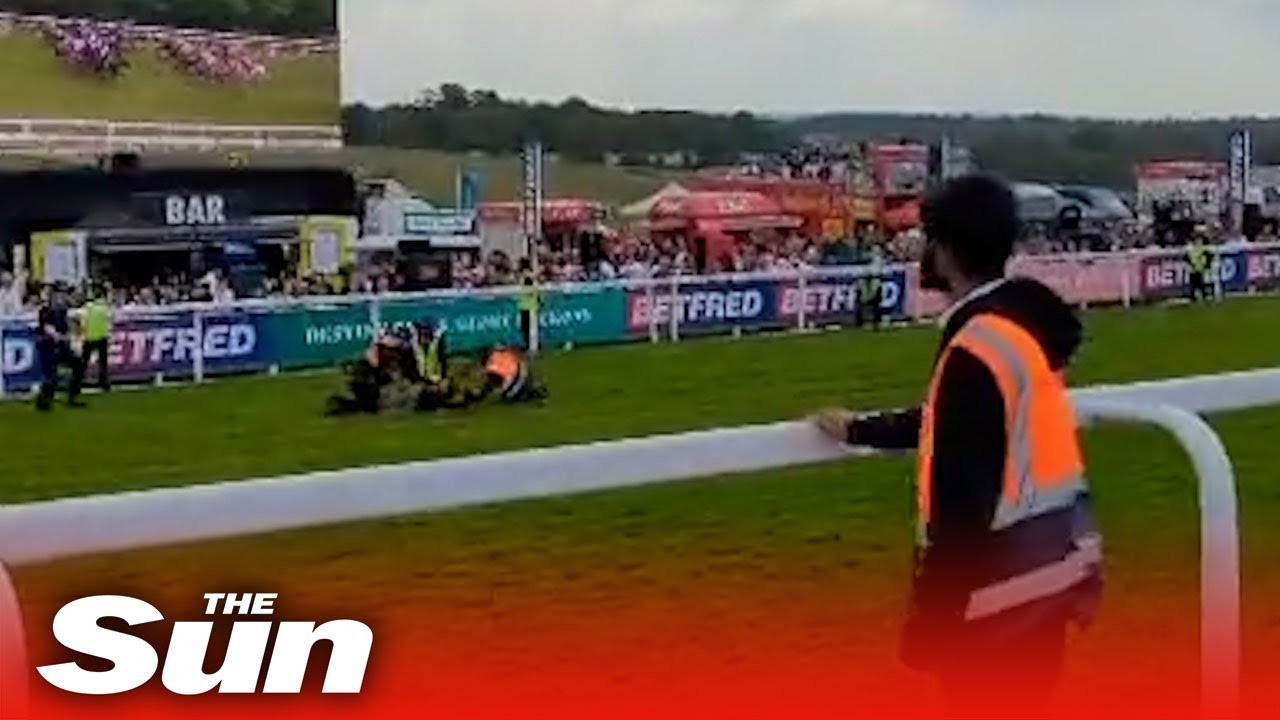 Moment protester is removed from Epsom racecourse track amid animal rights action