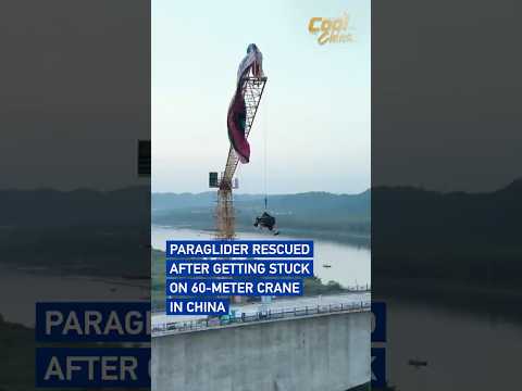 Paraglider rescued after getting stuck on 60-meter crane in China #coolchina