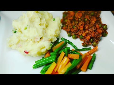 Creamy and fluffly mashed potatoes with minced meat and peas stew