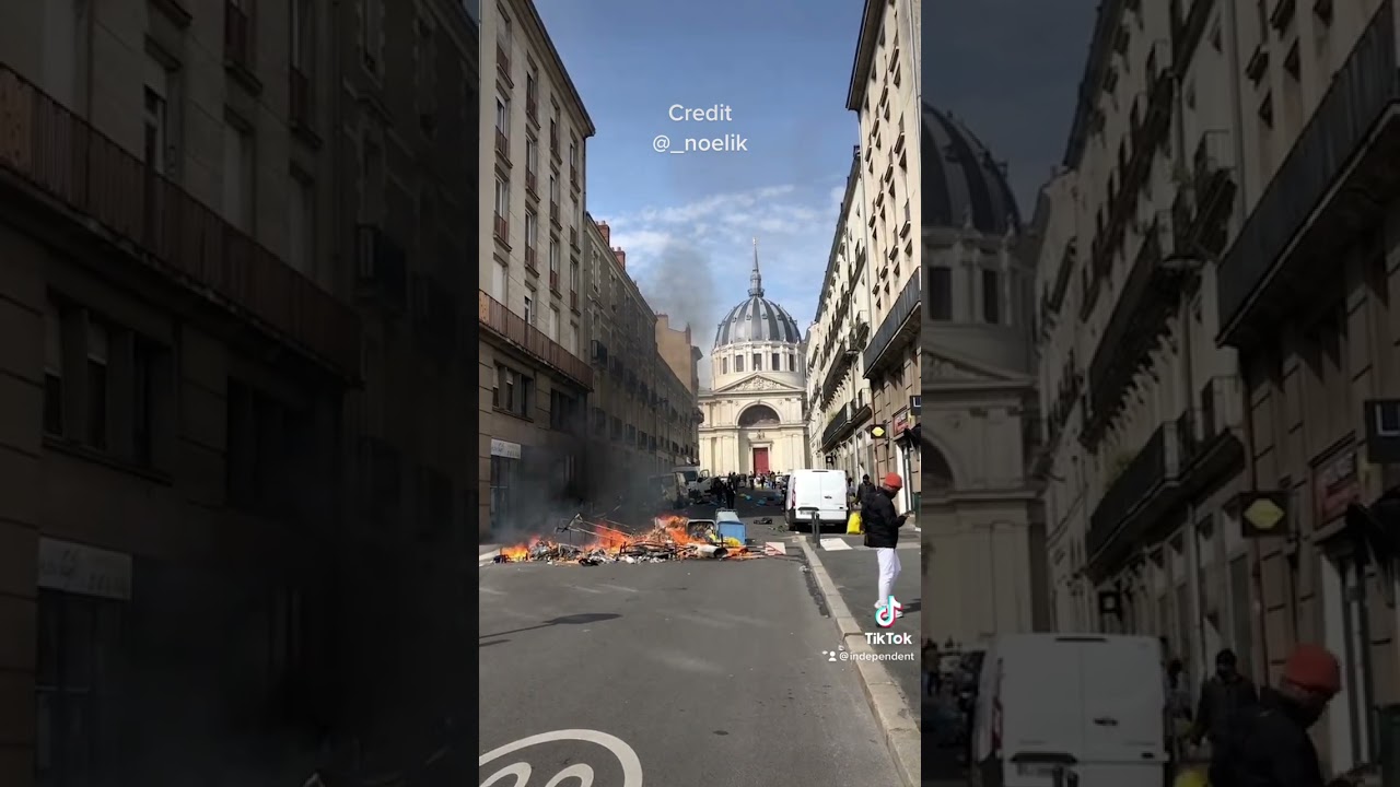 Passerby casually strolls past fire lit by protesters in France #shorts