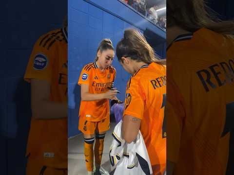 Olga Carmona y Alba Redondo firmando camisetas tras el partido