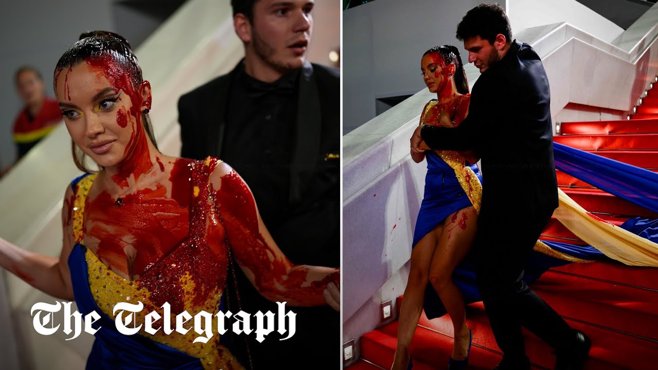 Protester dressed in Ukrainian flag colours drenches herself in fake blood on Cannes red carpet
