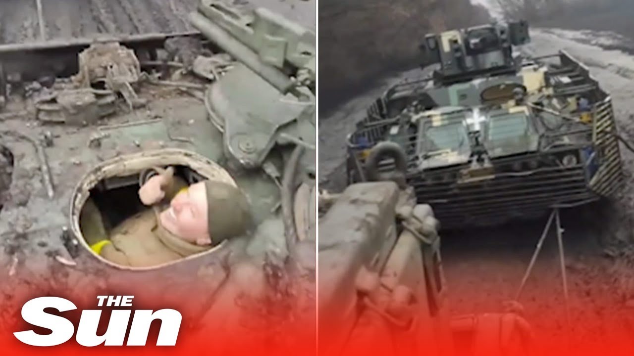 Ukrainians tow armoured vehicles through the mud using tanks in winter