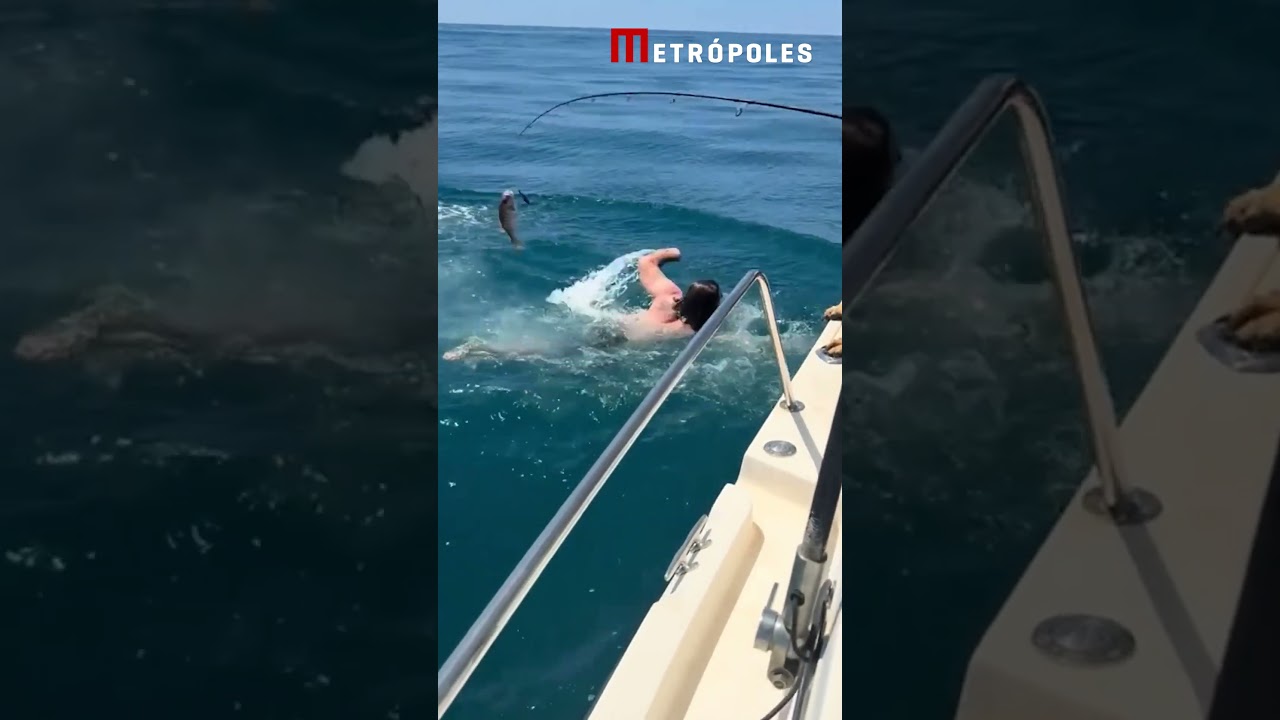 Homem pula sobre tubarão enquanto mulher pescava em alto ma