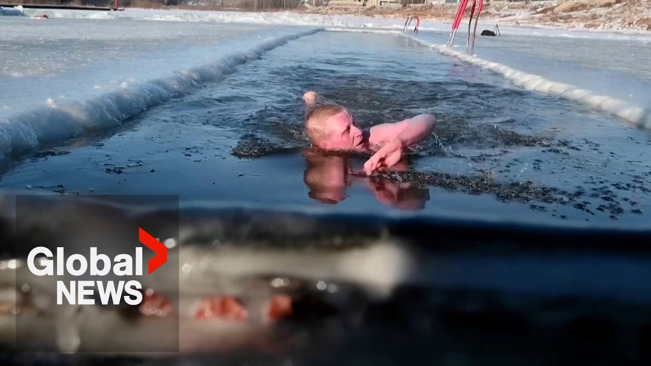 Siberian enthusiasts plunge into ice-cold river to kick off winter swimming season