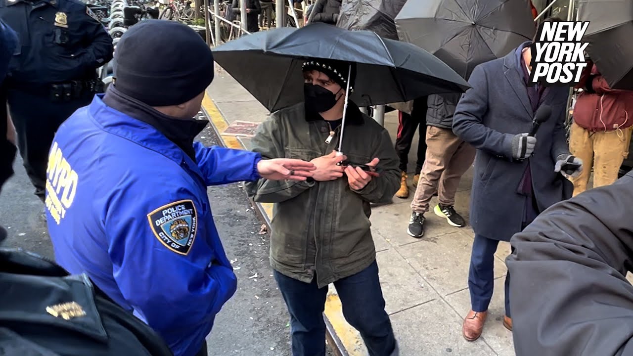 Migrant standoff in NYC turns ugly as 10 outside activists move against media with open umbrellas