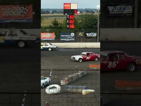 Pure stock car gets a helping bump to spin out in front of another car. #dirttrackracing #dirttrack - dirt track racing video image
