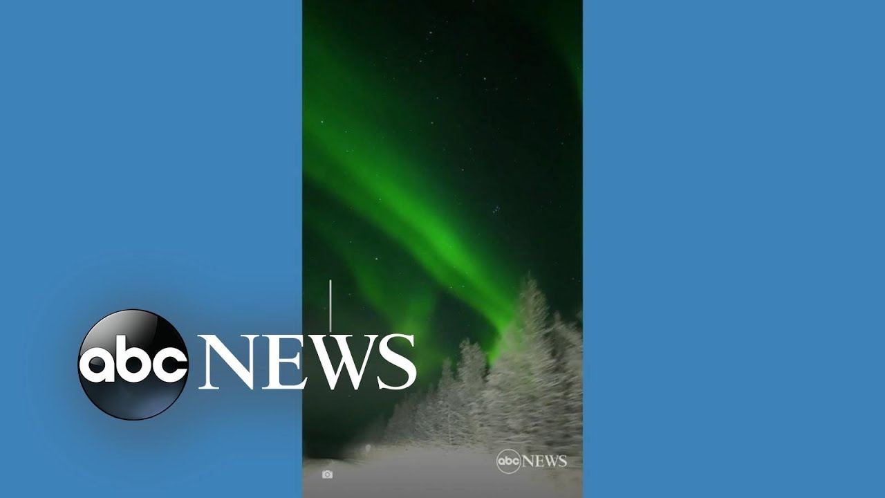 Aurora illuminates snow-covered road in Alaska