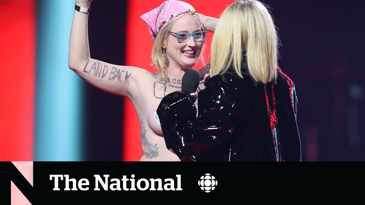 Avril Lavigne tells topless protester to get off stage